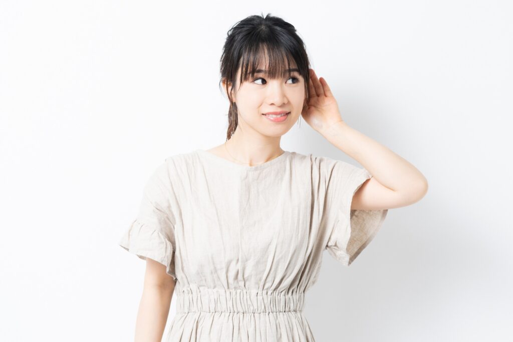 APD（聴覚情報処理障害）のイメージ。周囲に複数の音や会話がある環境の中で、特定の会話を聞き取ることが難しい状況を表しています。APDは聴力検査では異常がないことも多いものの、脳で音声情報を処理する過程に困難があり、会話の聞き取りが難しくなることがあります。特に騒がしい場所や複数人での会話、早口の説明などで理解が難しくなることがあり、学校や職場などの日常生活で困りごとを感じる場合があります。APDは聴覚情報処理障害とも呼ばれ、聞こえに関する特性として理解されつつある状態を説明するイメージです。